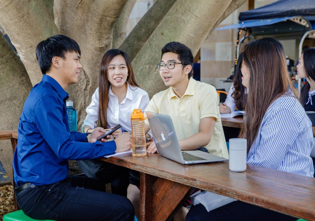 Group of students sitting together having a chat at The University of Queensland's St Lucia campus